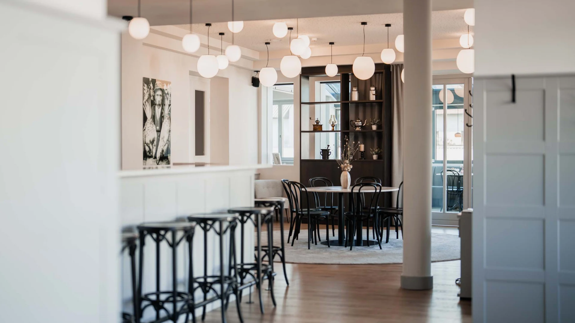 Unser Hotel in Weiden am See: ein Schmuckstück Moderner heller Gastraum mit Barhockern und rundem Tisch mit Stühlen