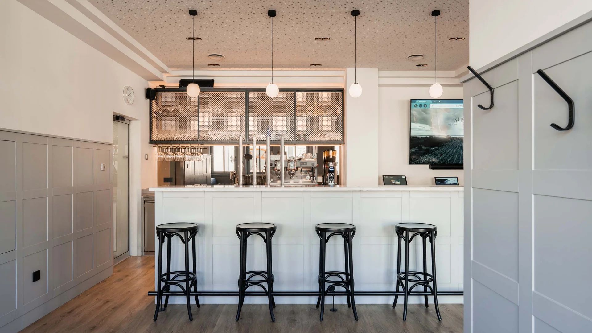 Luis von Weyden: your stylish guesthouse in Weiden am See Modern bright bar area with four black stools and three hanging lamps