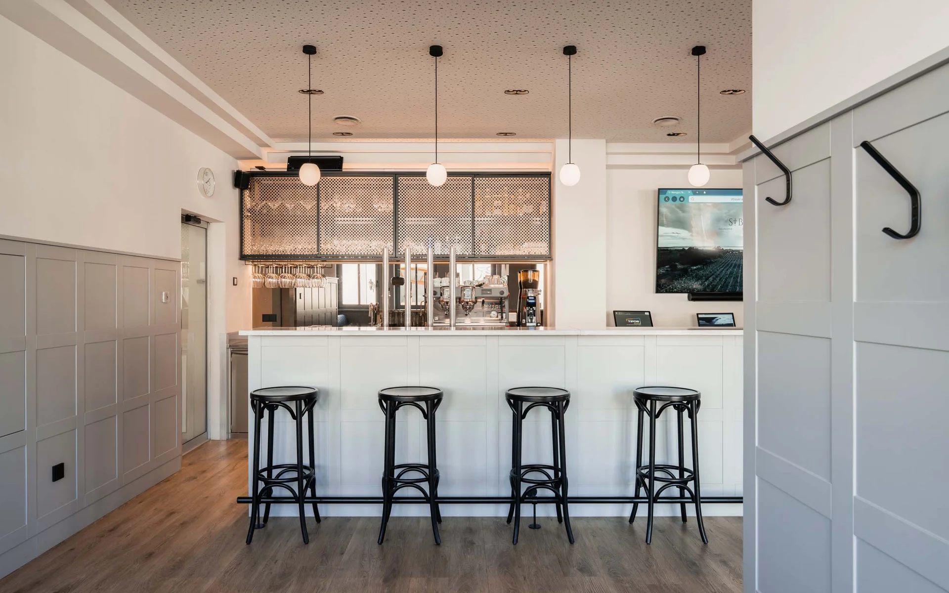 Luis von Weyden: your stylish guesthouse in Weiden am See Modern bright bar area with four black stools and three hanging lamps