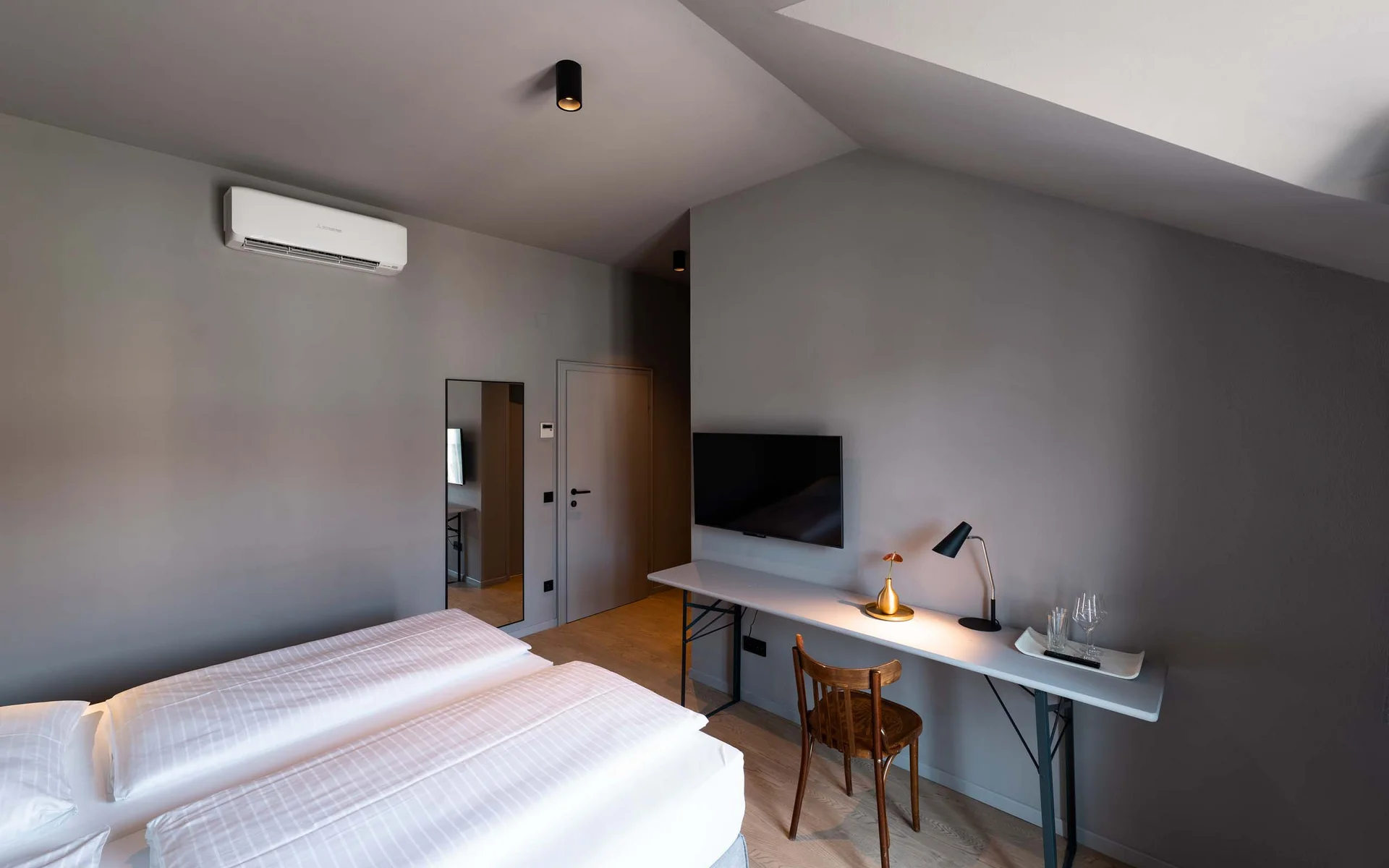 Luis von Weyden: your stylish guesthouse in Weiden am See Modern hotel room with double bed, desk, TV, and air conditioner