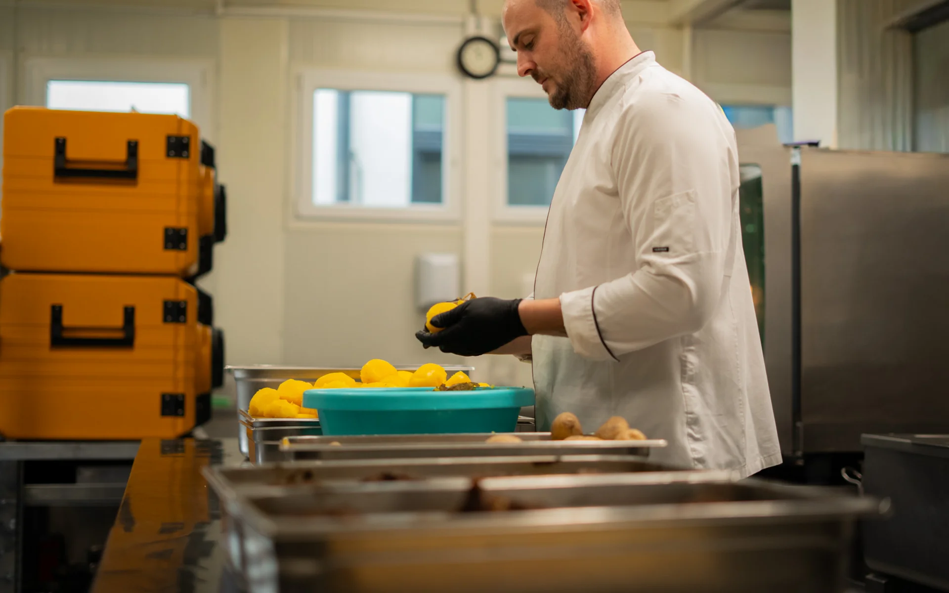 Koch schält gelbe Kartoffeln in einer Großküche