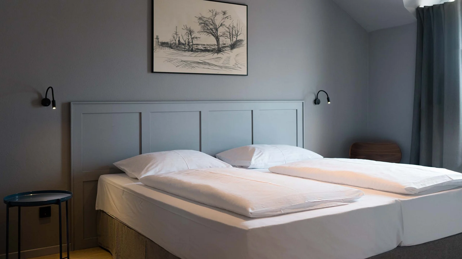 Luis von Weyden: your stylish guesthouse in Weiden am See Modern bedroom with double bed, gray walls, and wooden floor