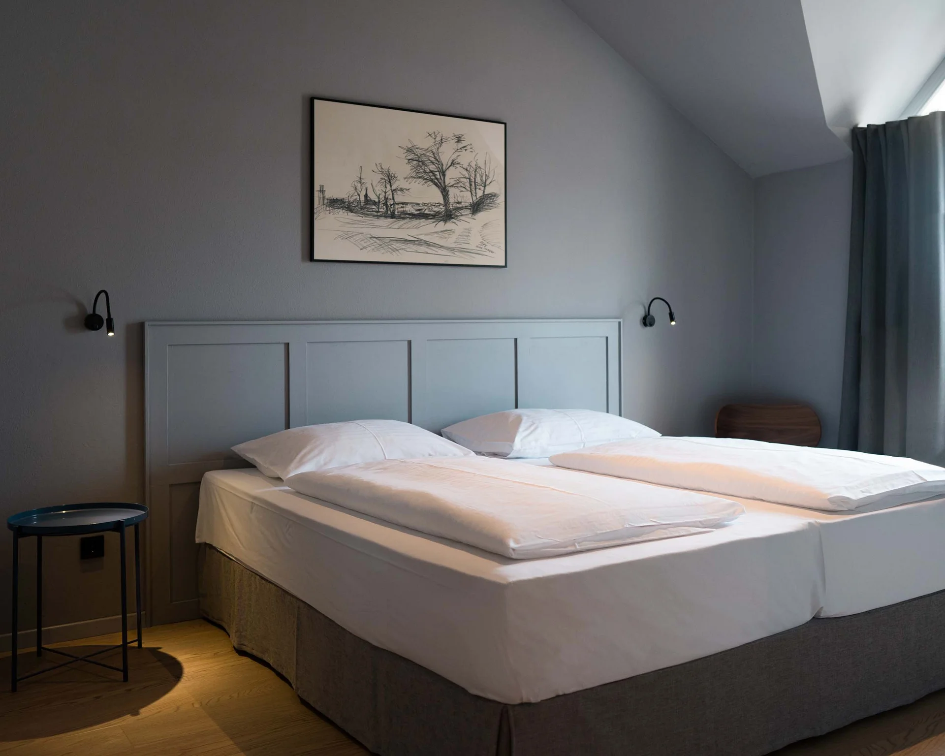 Modernes Schlafzimmer mit Doppelbett, grauen Wänden und Holzboden