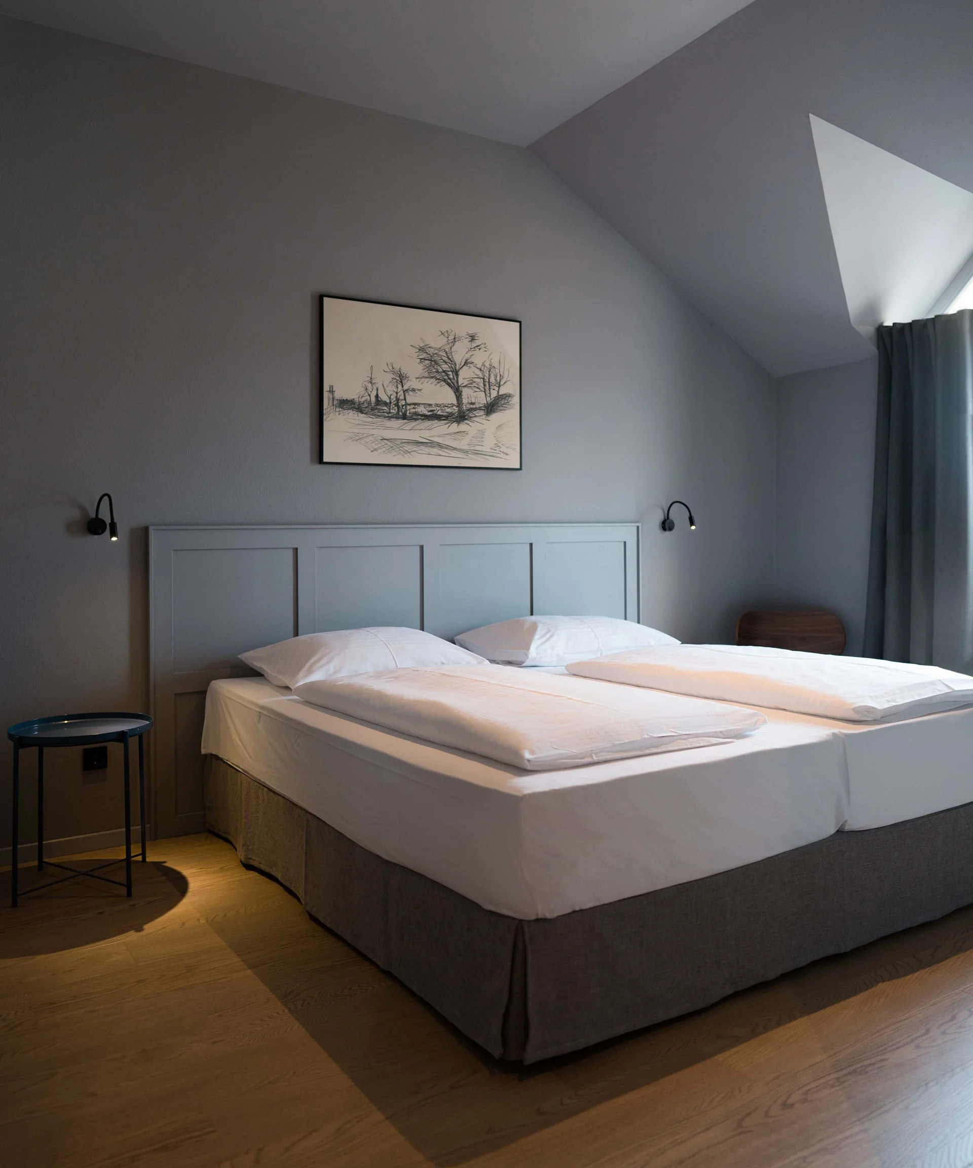 Modernes Schlafzimmer mit Doppelbett, grauen Wänden und Holzboden