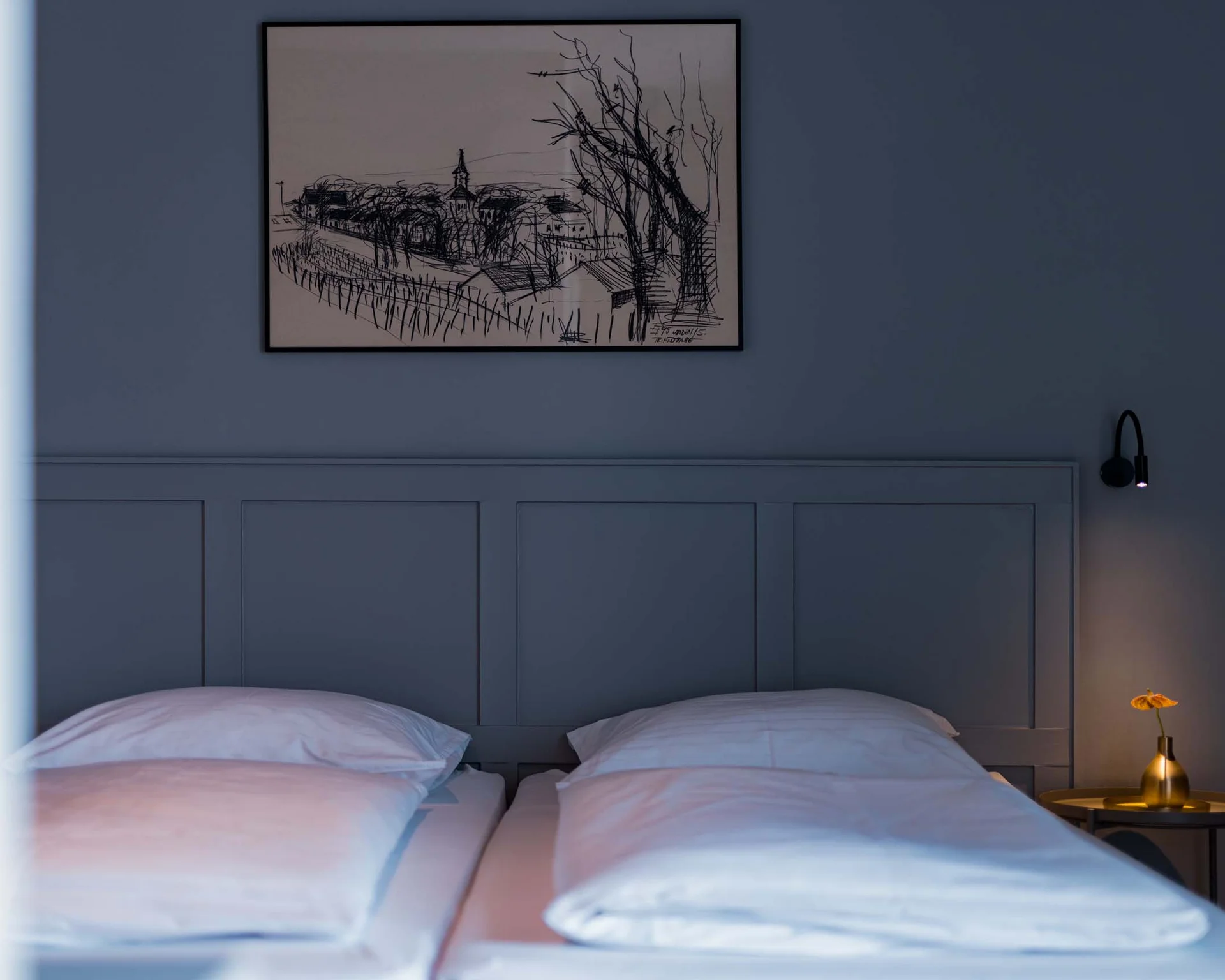 Gemütliches Schlafzimmer mit zwei Betten, kleinem Nachttisch und Wandbild