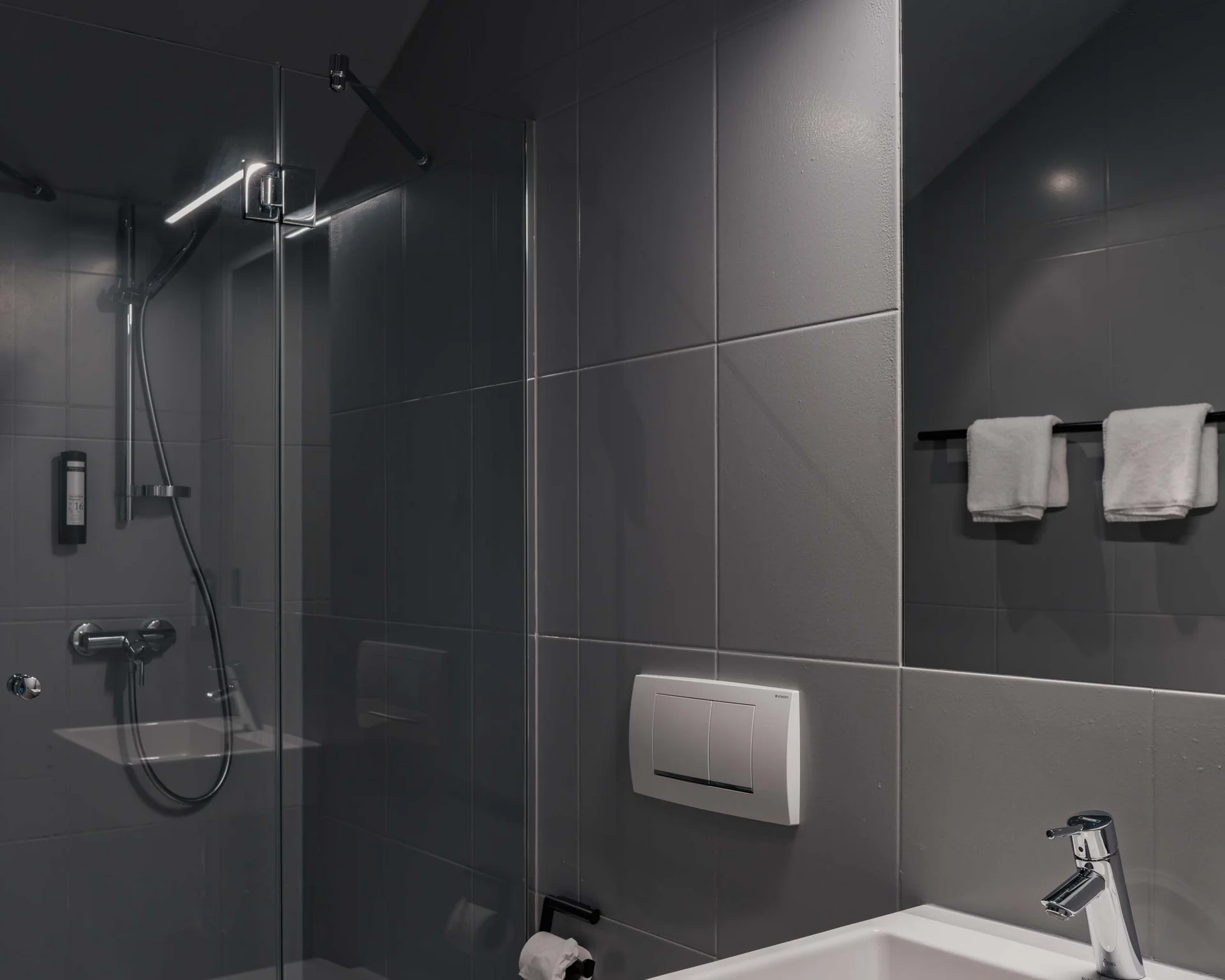 Modernes Badezimmer mit Dusche, Toilette und Waschbecken in grauem Design