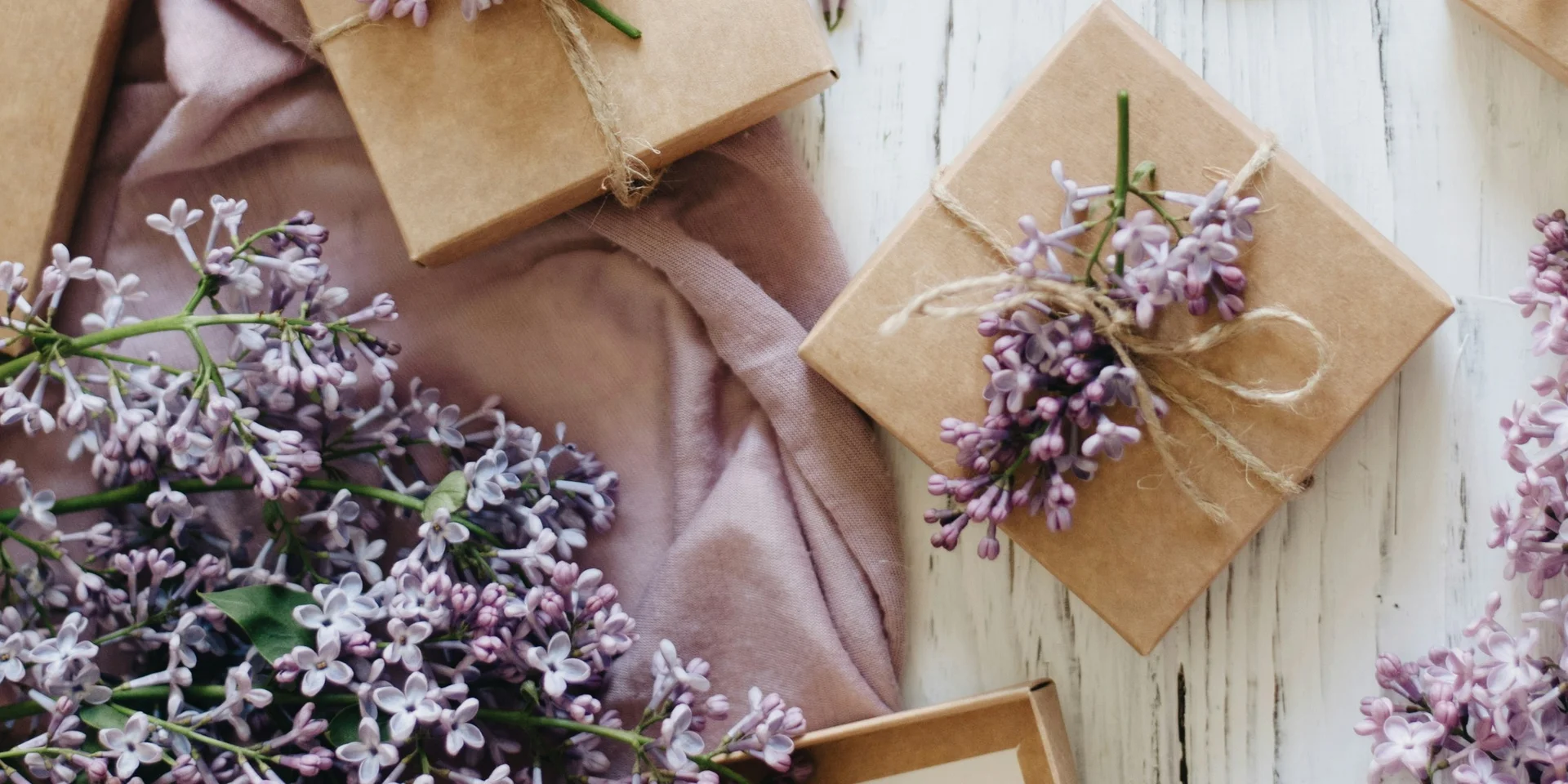 Lavendelzweige, Schere und Geschenkkarten auf weißem Holztisch