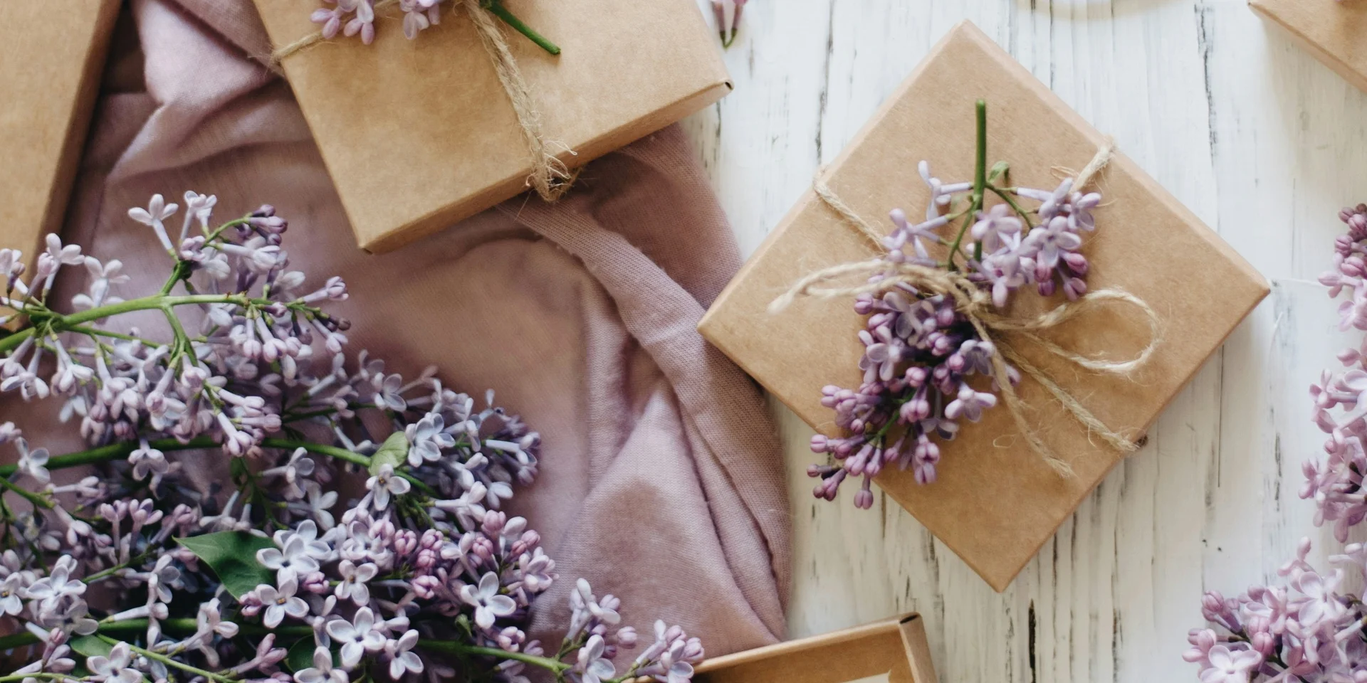 Lavendelzweige, Schere und Geschenkkarten auf weißem Holztisch