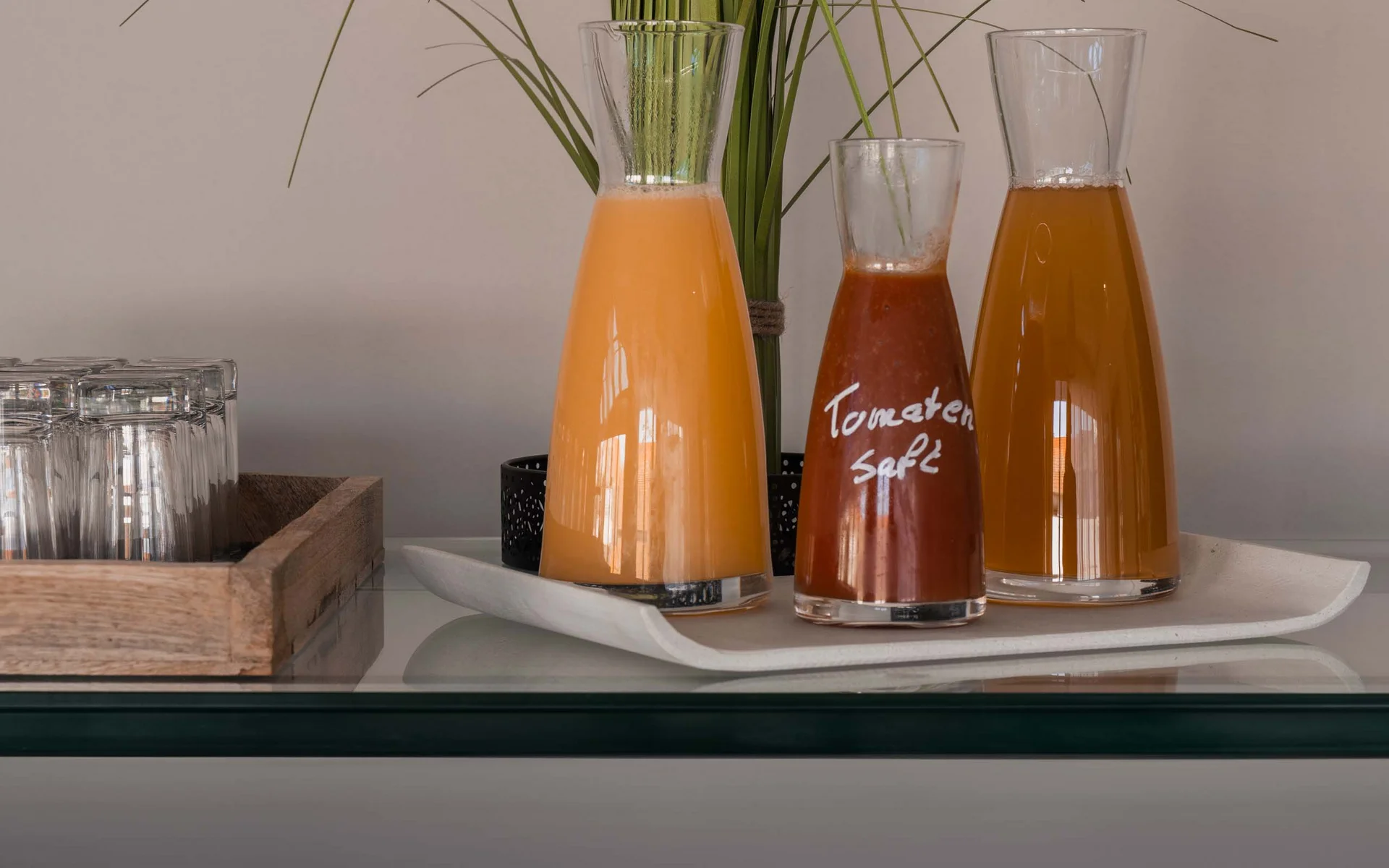 Karaffen mit Säften und frisches Gemüse auf Buffet mit Beschriftungen