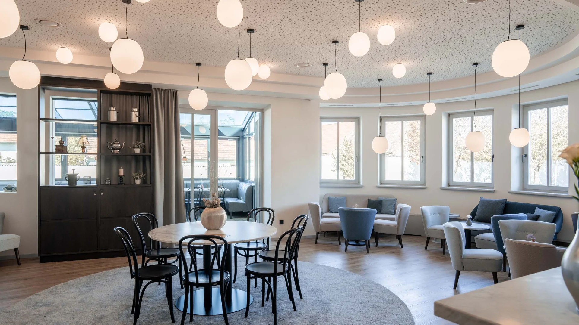 Luis von Weyden: your stylish guesthouse in Weiden am See Bright modern lounge with round tables and oval pendant lights